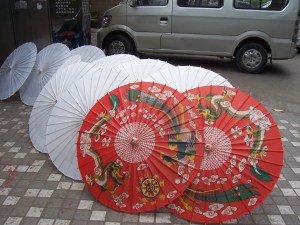 Recently glued and papered umbrellas, drying in the sun