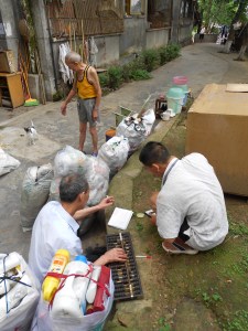 Our recycling guy and his driver both sort out the amounts, reweighing and recalculating, while Mr. River looks on.
