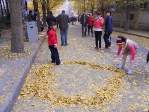 We all love to play in fall leaves. These kids are creating a golden heart.