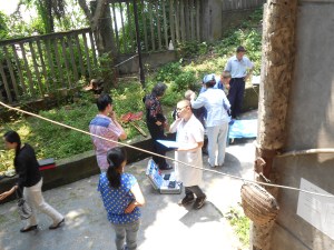Mr. Wang being looked after by the arrival of the ambulance medical team.  The nurse is dressing Mr. Wang's head; the doctor talking to Mr. Huang about his injury.